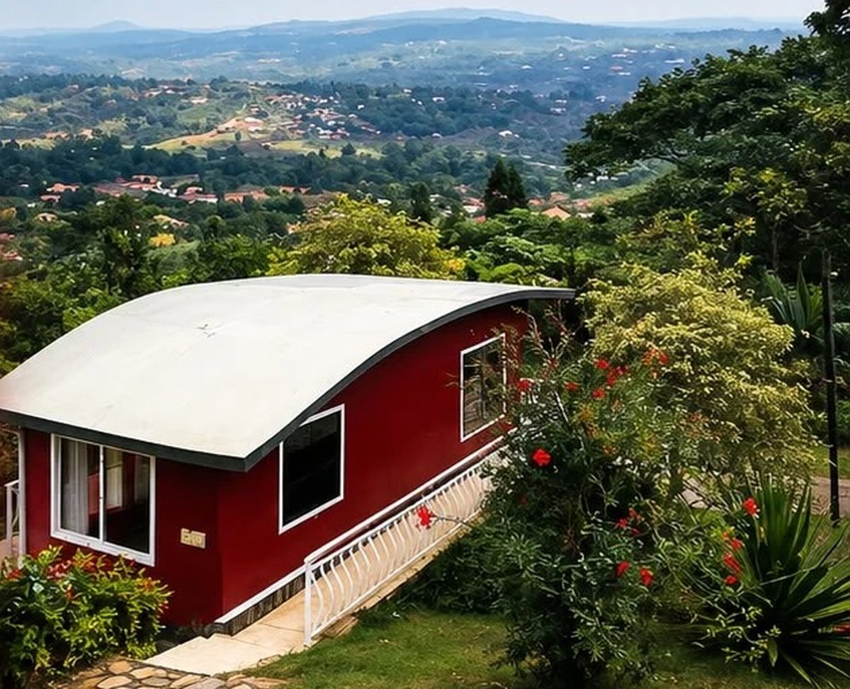 A premium red cottage exterior overlooking the valley at Maya Nature Resort