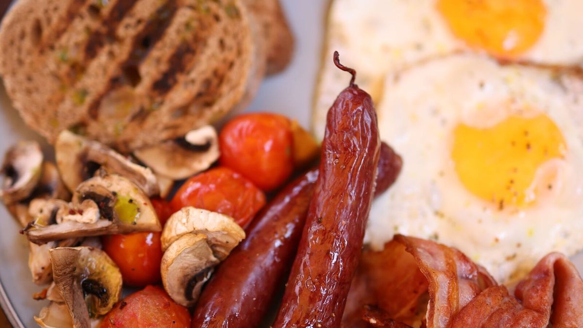 Full English breakfast with eggs, sausages, bacon, mushrooms and tomatoes