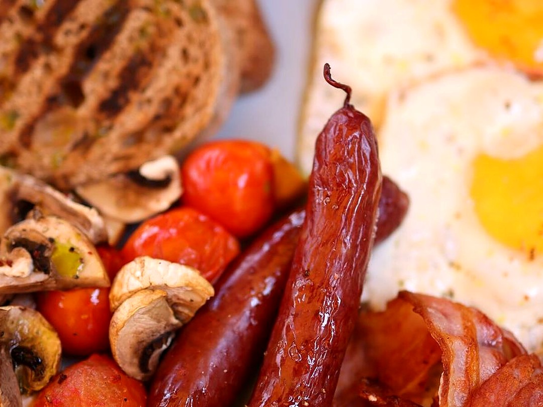 A hearty full breakfast — eggs, sausages, bacon, mushrooms and grilled toast at Maya Nature Resort