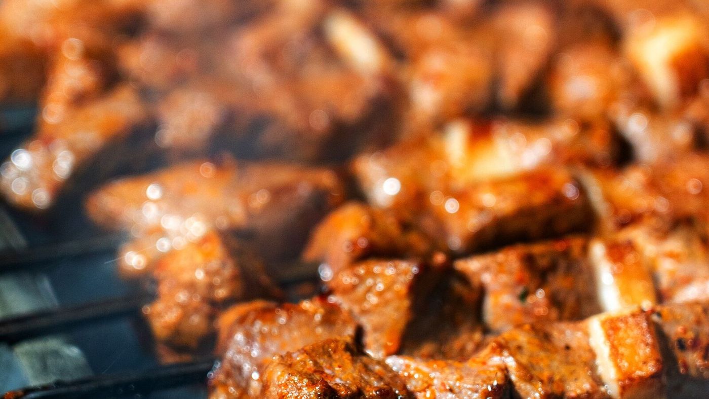 Seasoned meat skewers grilling over charcoal