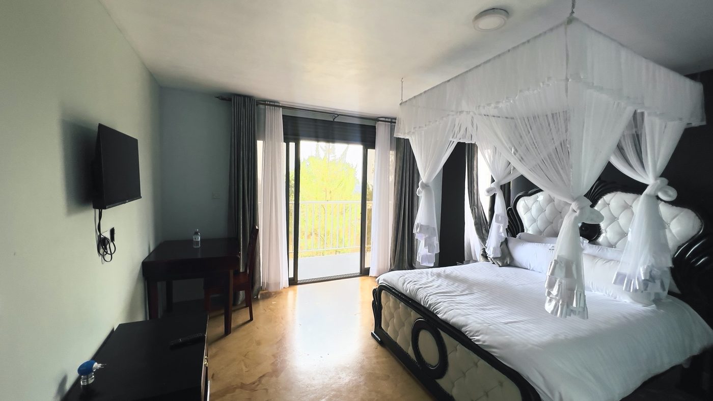 Spacious room interior at Maya Nature Resort with a four-poster bed.